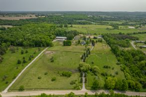 Aerial showing 2 houses, 2 long private driveways, 2 barns, pond, tennis court, indoor arena - Country homes for sale and luxury real estate including horse farms and property in the Caledon and King City areas near Toronto